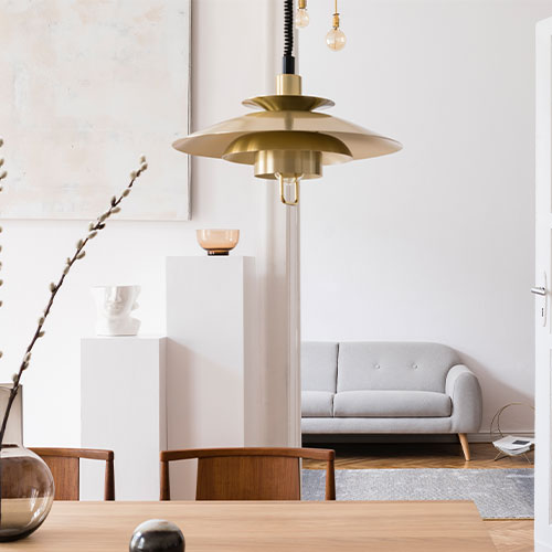 Stylish scandi interior of home space with design grey sofa.