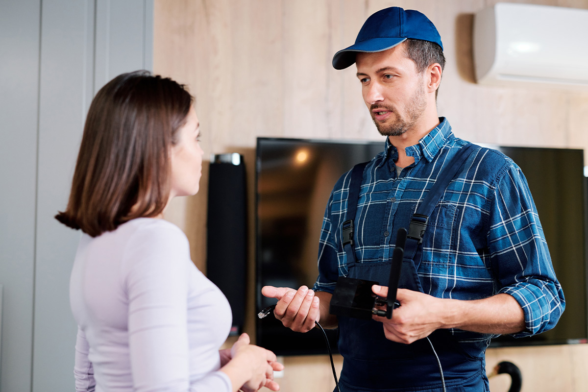 Young master of repair service explaining one of clients how to use device