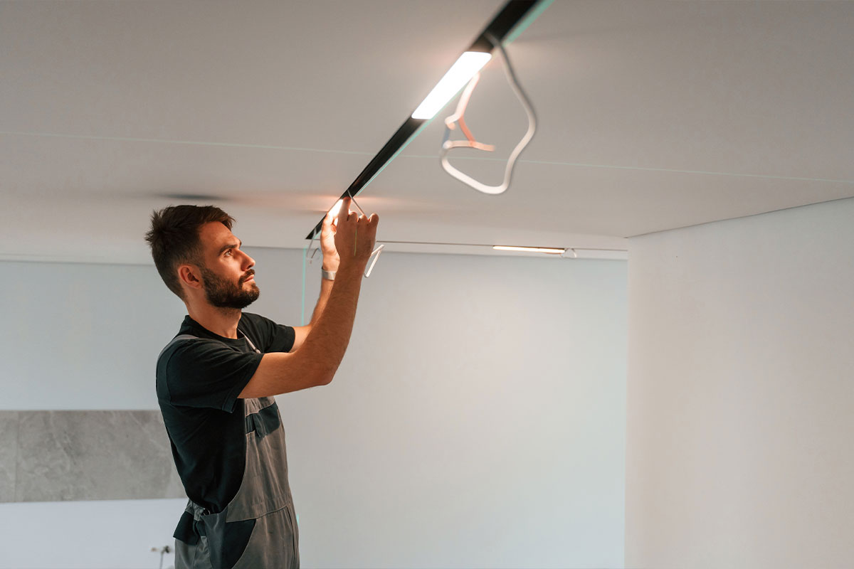 Man is working with lighting equipment indoors at domestic room