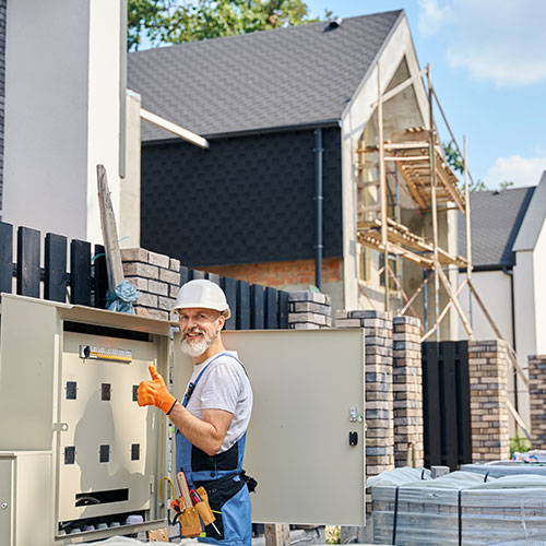 Electrician approving power distribution box installation on site
