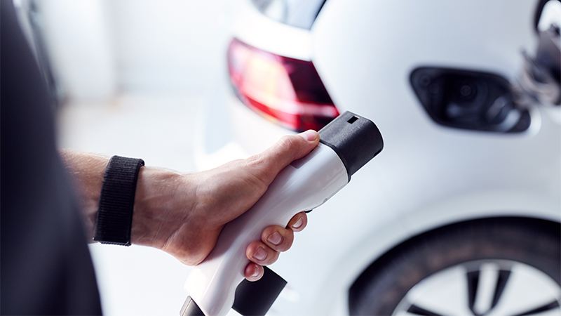 person charding his car in home with ev charger